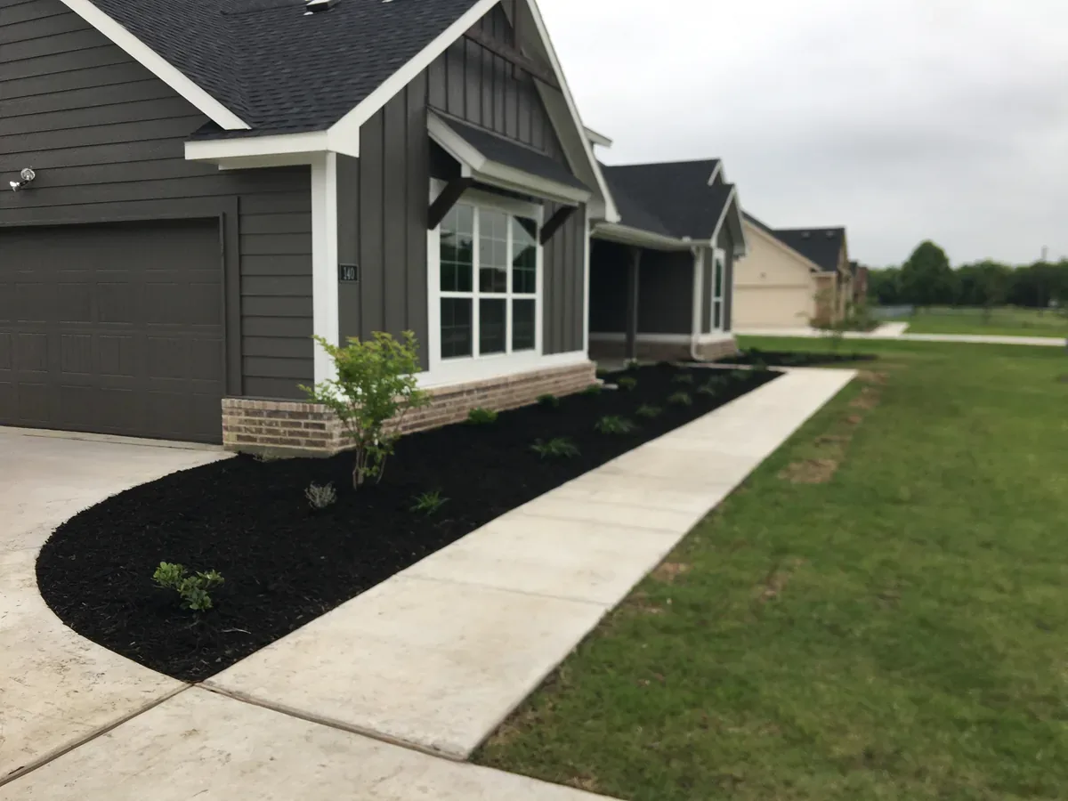 Curved mulch bed running along the edge of a driveway