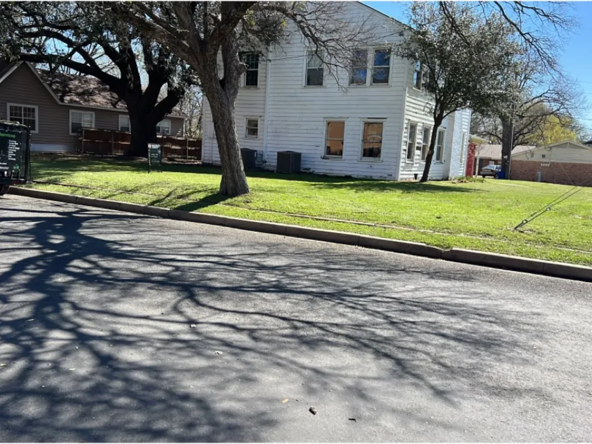 Shaded front lawn mowed along a residential street